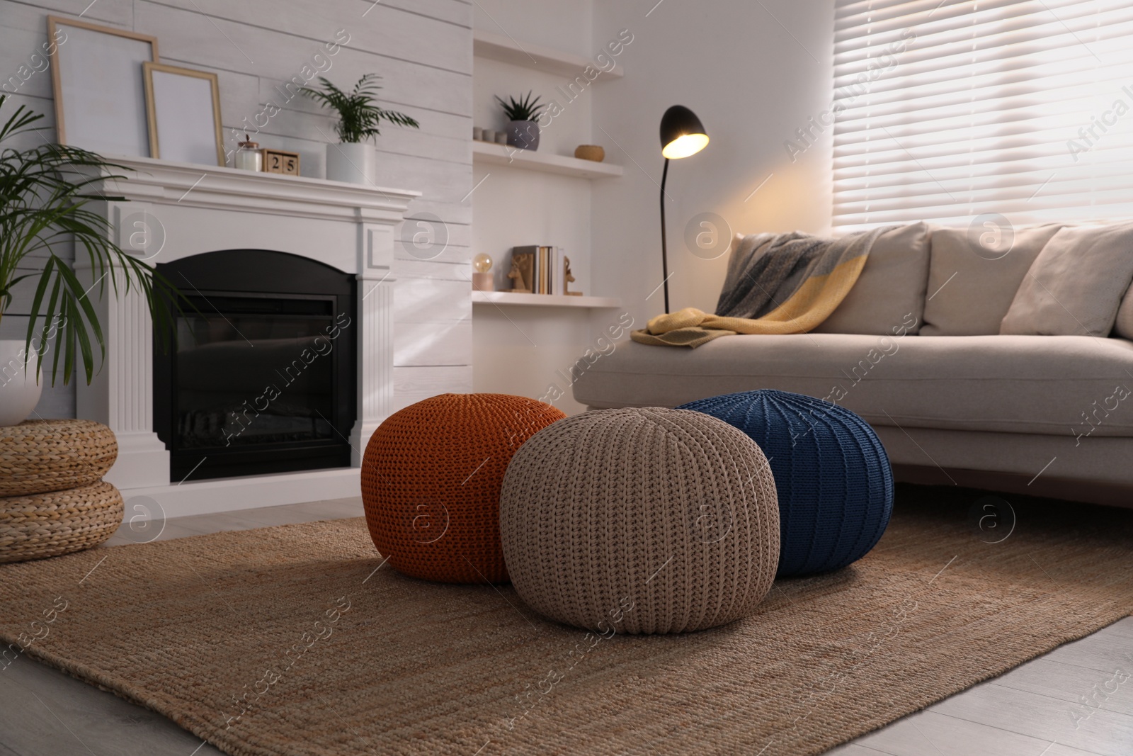 Photo of Stylish comfortable poufs near sofa in room. Home design