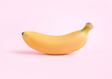 Photo of One sweet ripe baby banana on light pink background