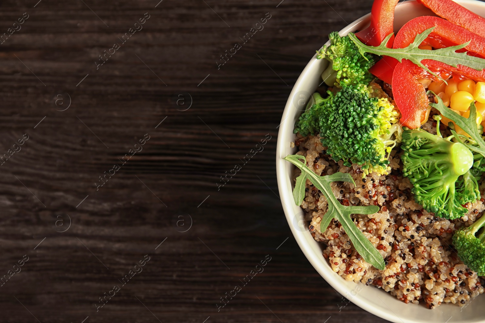 Photo of Bowl with quinoa and garnish on table, top view. Space for text