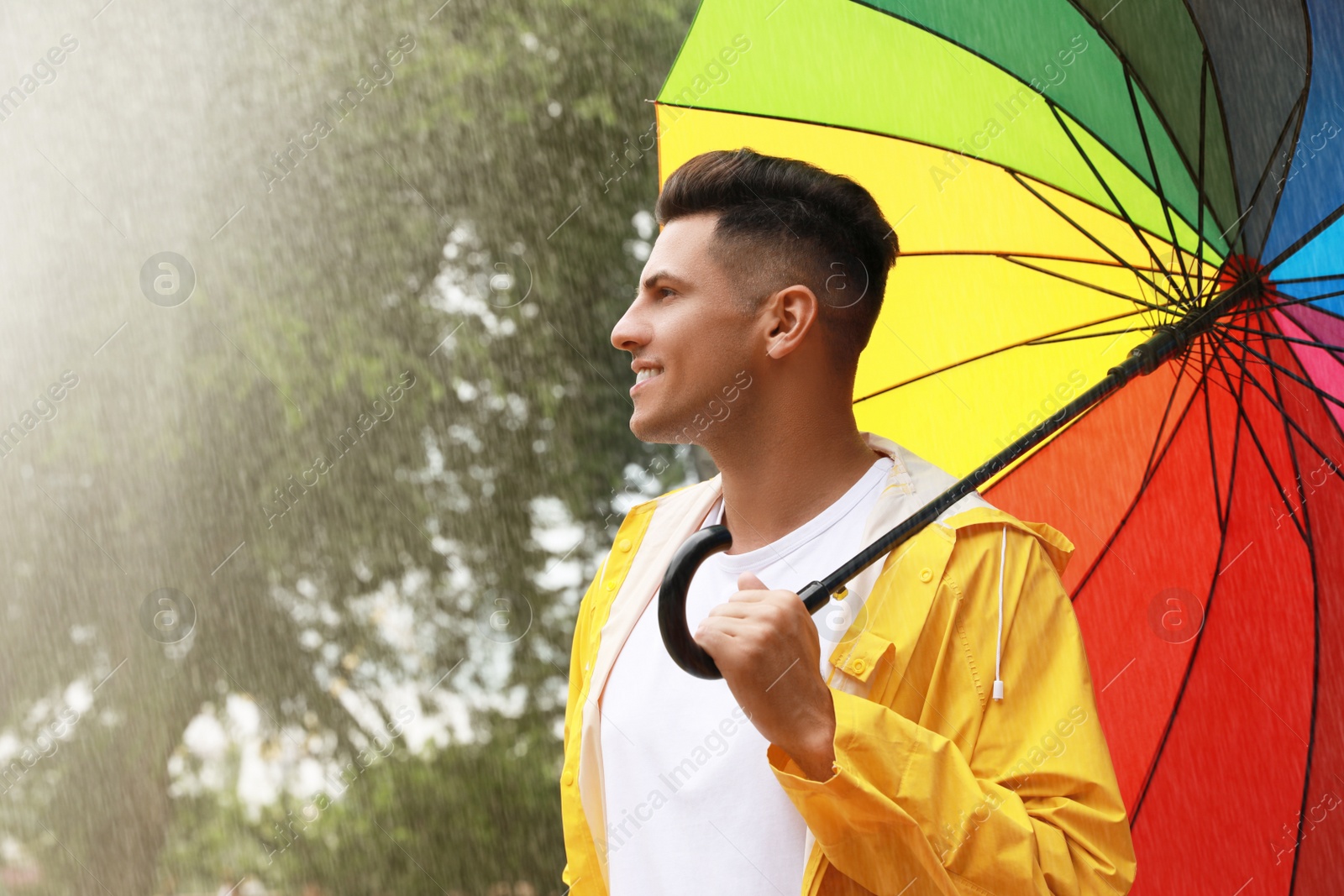 Photo of Man with umbrella walking under rain in park