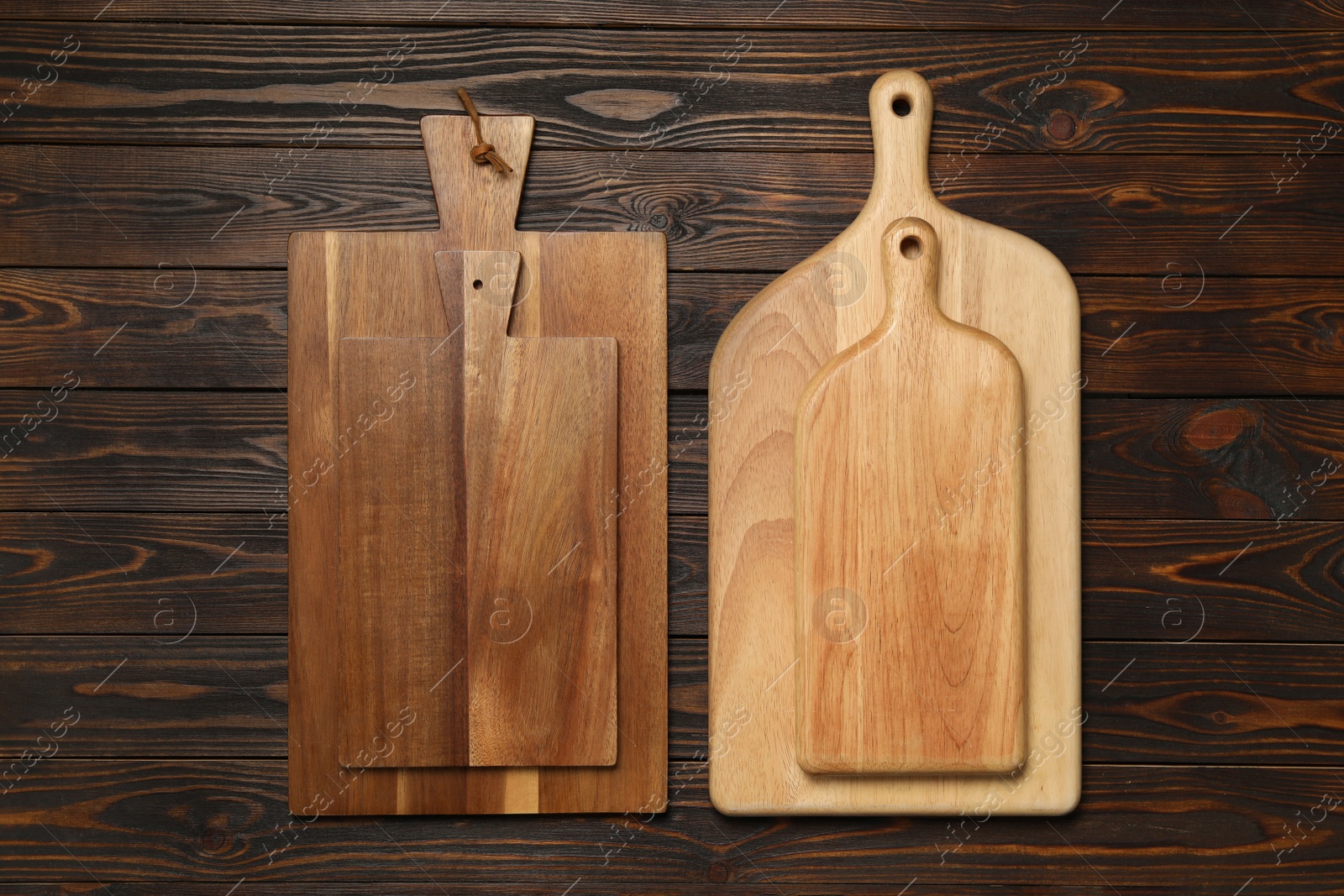 Photo of Set of wooden boards on brown table, flat lay. Cooking utensils