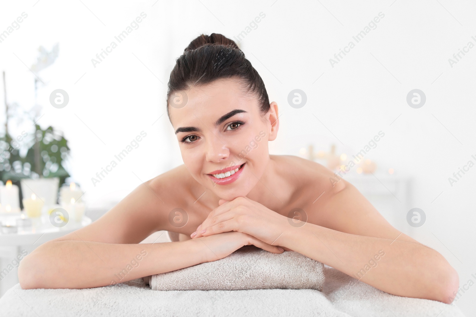 Photo of Young woman lying on massage table in spa salon