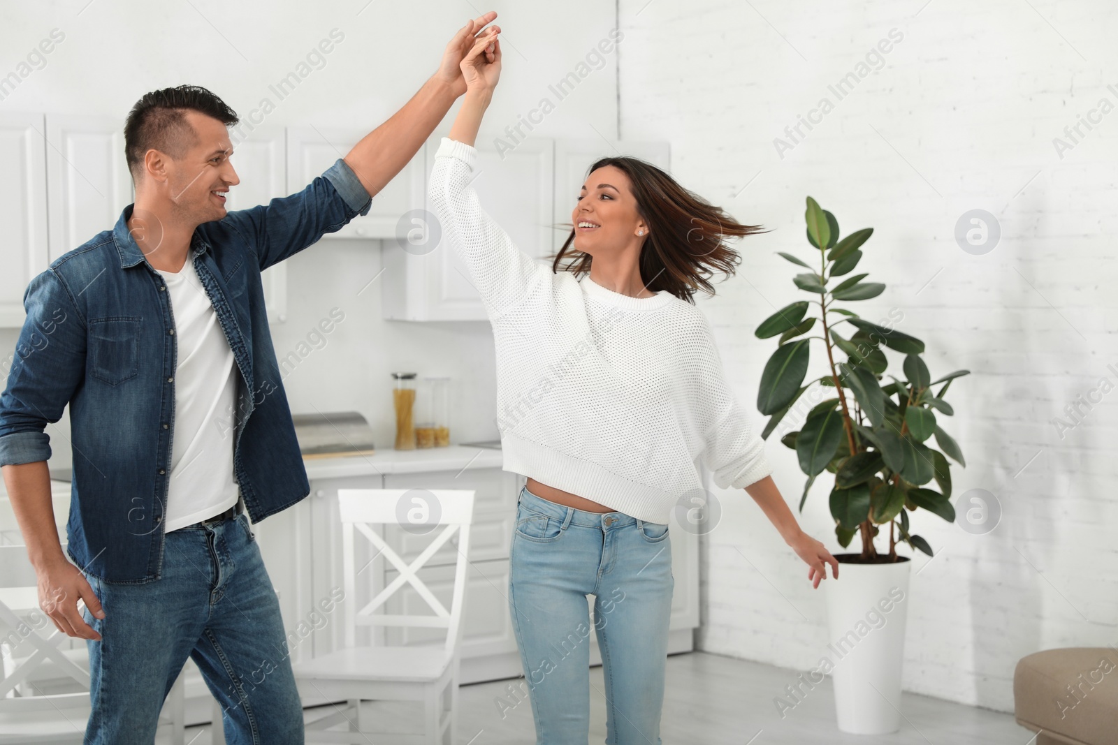 Photo of Happy couple dancing in kitchen at home