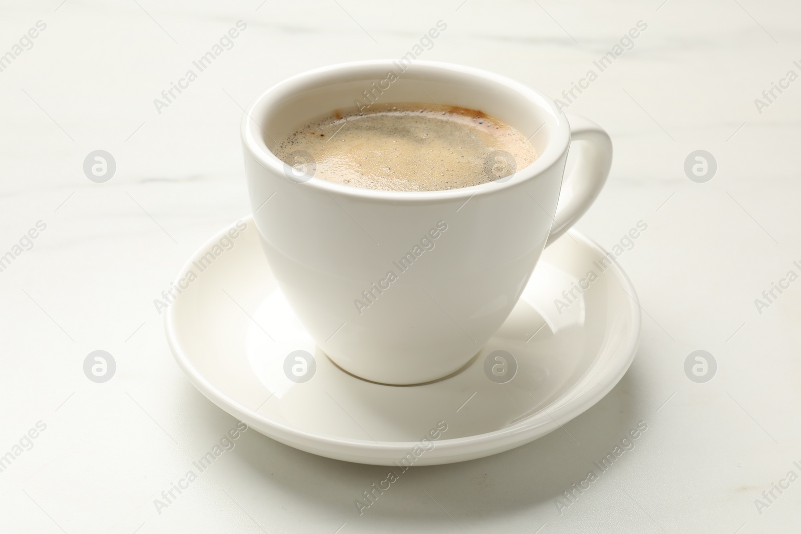 Photo of Cup of aromatic coffee on white table, closeup