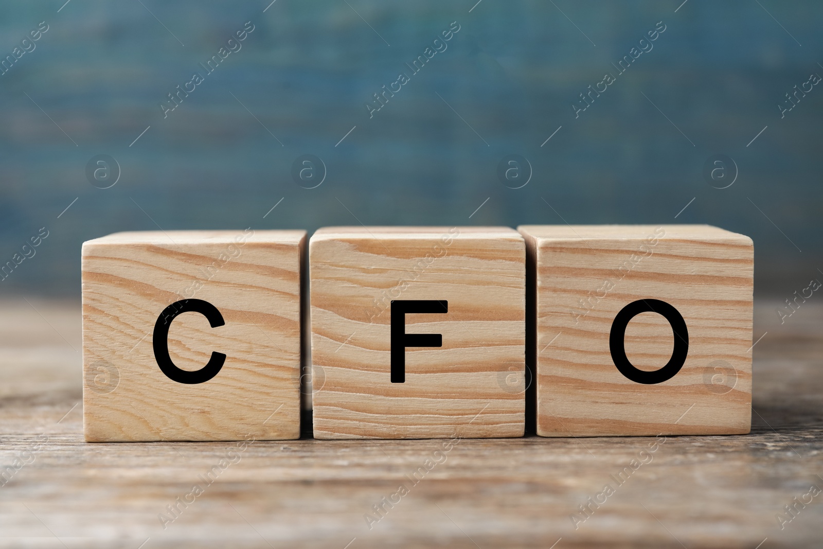 Photo of Abbreviation CFO of wooden cubes on table, closeup. Financial management