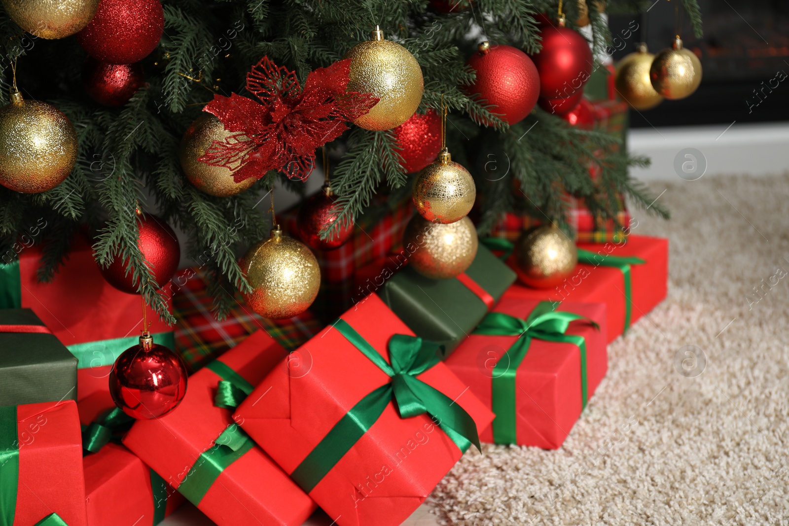 Photo of Many gift boxes under decorated Christmas tree in room