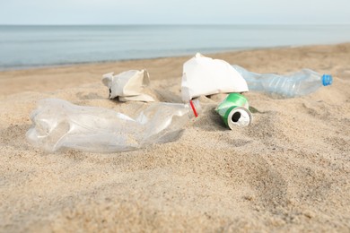 Garbage scattered on beach near sea. Recycling problem