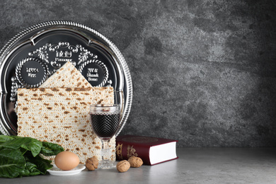 Symbolic Pesach (Passover Seder) items on grey table. Space for text