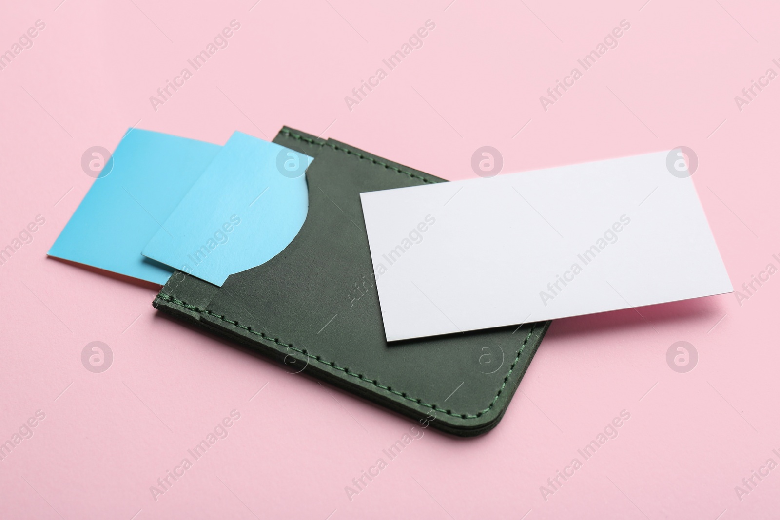 Photo of Leather business card holder with blank cards on pink background