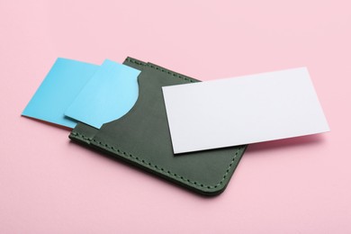 Photo of Leather business card holder with blank cards on pink background