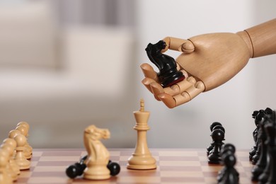 Photo of Wooden hand representing artificial intelligence. Robot with knight over chessboard against light background, closeup. Space for text