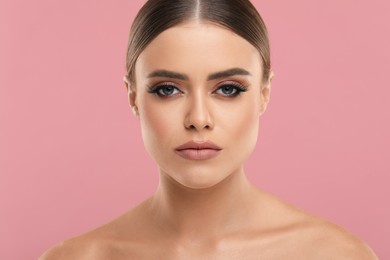 Beautiful woman with makeup on pink background