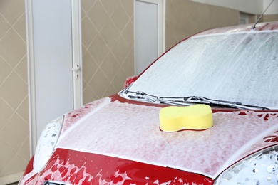 Photo of Automobile with sponge on its bonnet at car wash