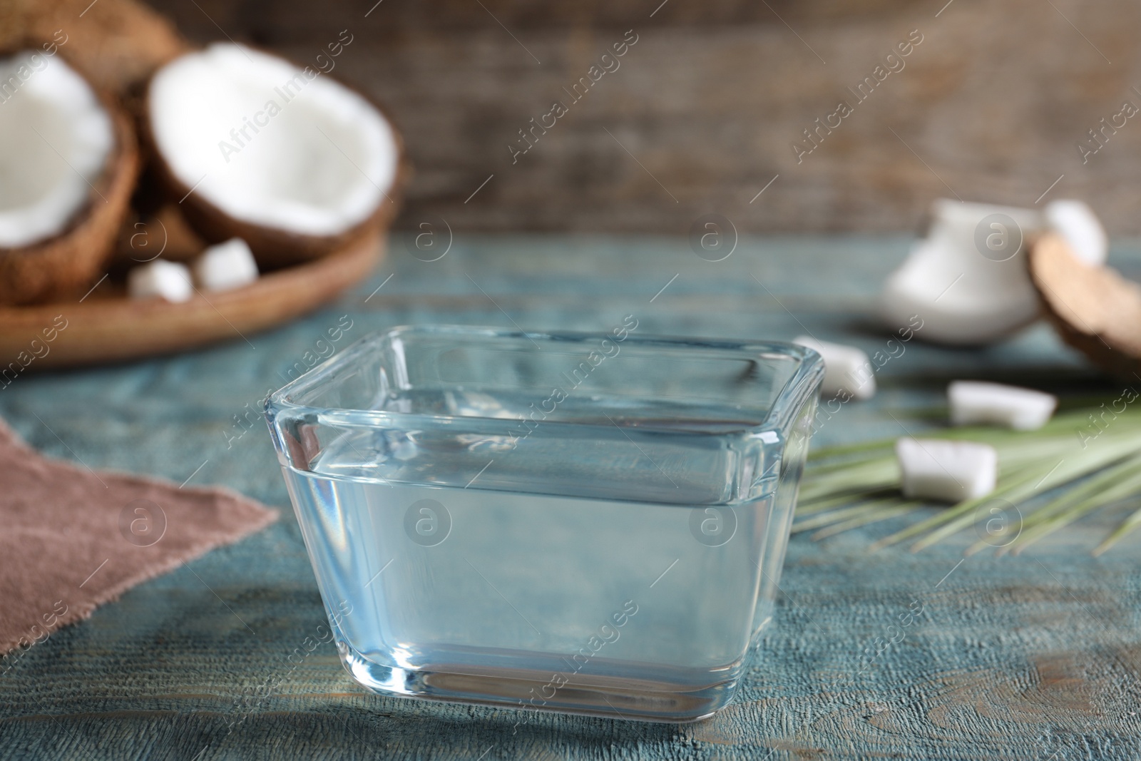 Photo of Coconut oil on light blue wooden table