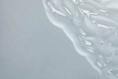 Transparent cleansing gel on light grey background, top view with space for text. Cosmetic product