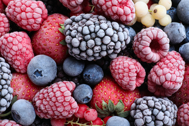 Photo of Mix of different frozen berries as background, top view