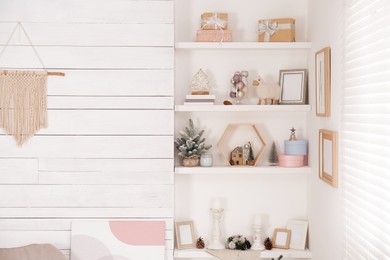 Wall shelves with beautiful Christmas decor indoors. Interior design