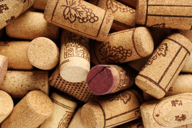 Photo of Many corks of wine bottles with grape images as background, top view