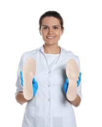 Photo of Beautiful female orthopedist showing insoles on white background