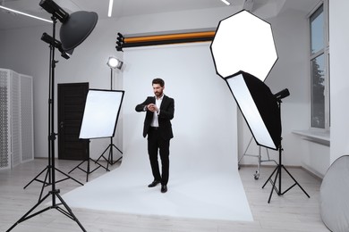 Photo of Handsome model posing in modern studio. Professional photo session