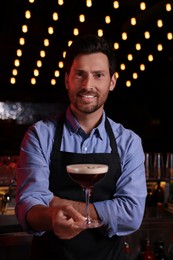 Photo of Bartender with Espresso Martini in bar. Alcohol cocktail