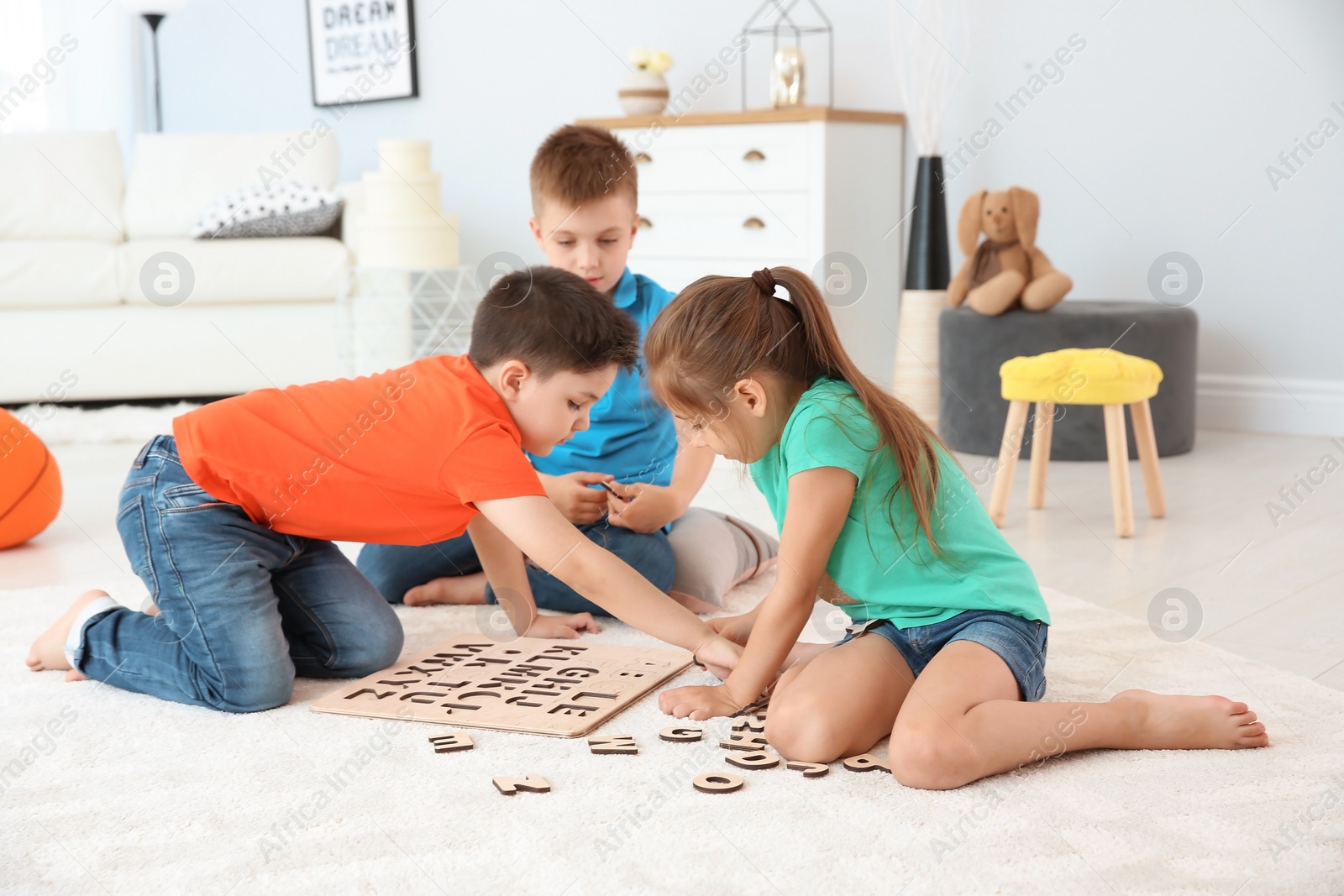 Photo of Cute little children playing together on floor, indoors