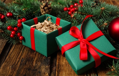 Green Christmas gift box with red bow on wooden table