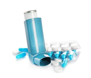 Asthma inhaler and pills on white background