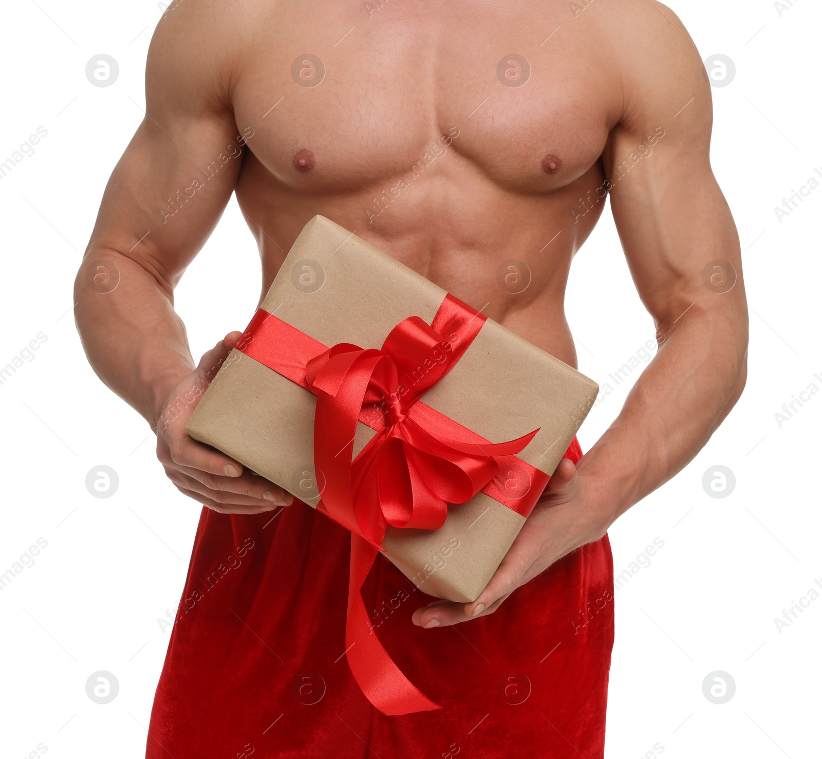 Photo of Attractive young man with muscular body in Santa hat holding Christmas gift box on white background, closeup