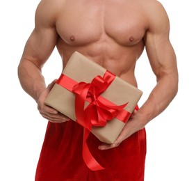 Photo of Attractive young man with muscular body in Santa hat holding Christmas gift box on white background, closeup