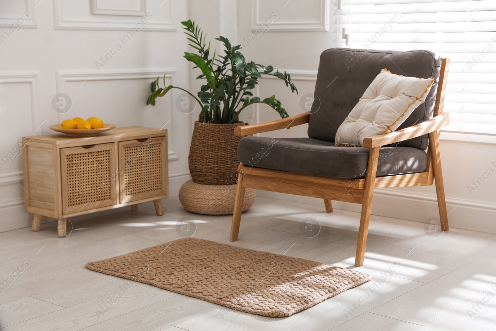 Photo of Stylish rug on floor near armchair in room