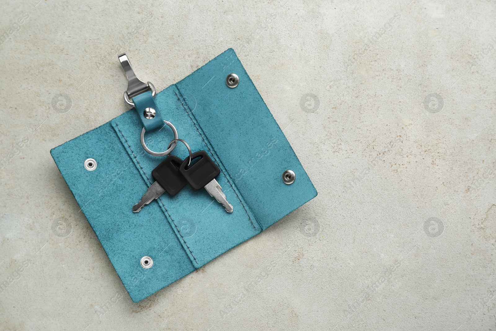 Photo of Stylish leather holder with keys on light grey table, top view. Space for text