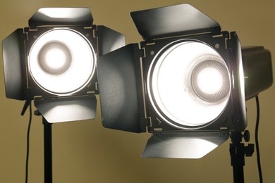 Two modern spotlights against beige background, closeup