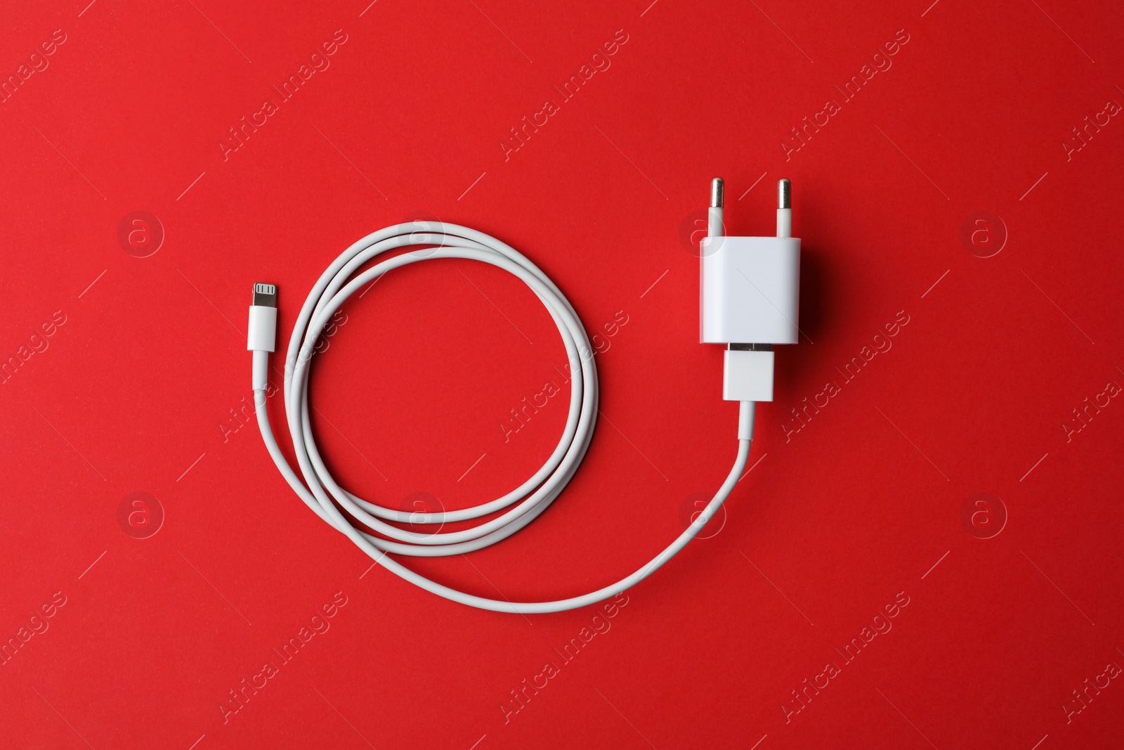 Photo of USB charger on red background, top view. Modern technology