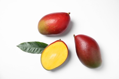 Photo of Tropical cut and whole mango with green leaf isolated on white, flat lay