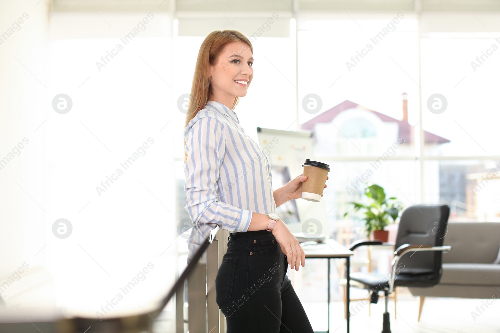 Photo of Young businesswoman with cup of coffee relaxing in office during break