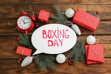 Photo of Flat lay composition with Boxing Day sign and Christmas gifts on wooden table