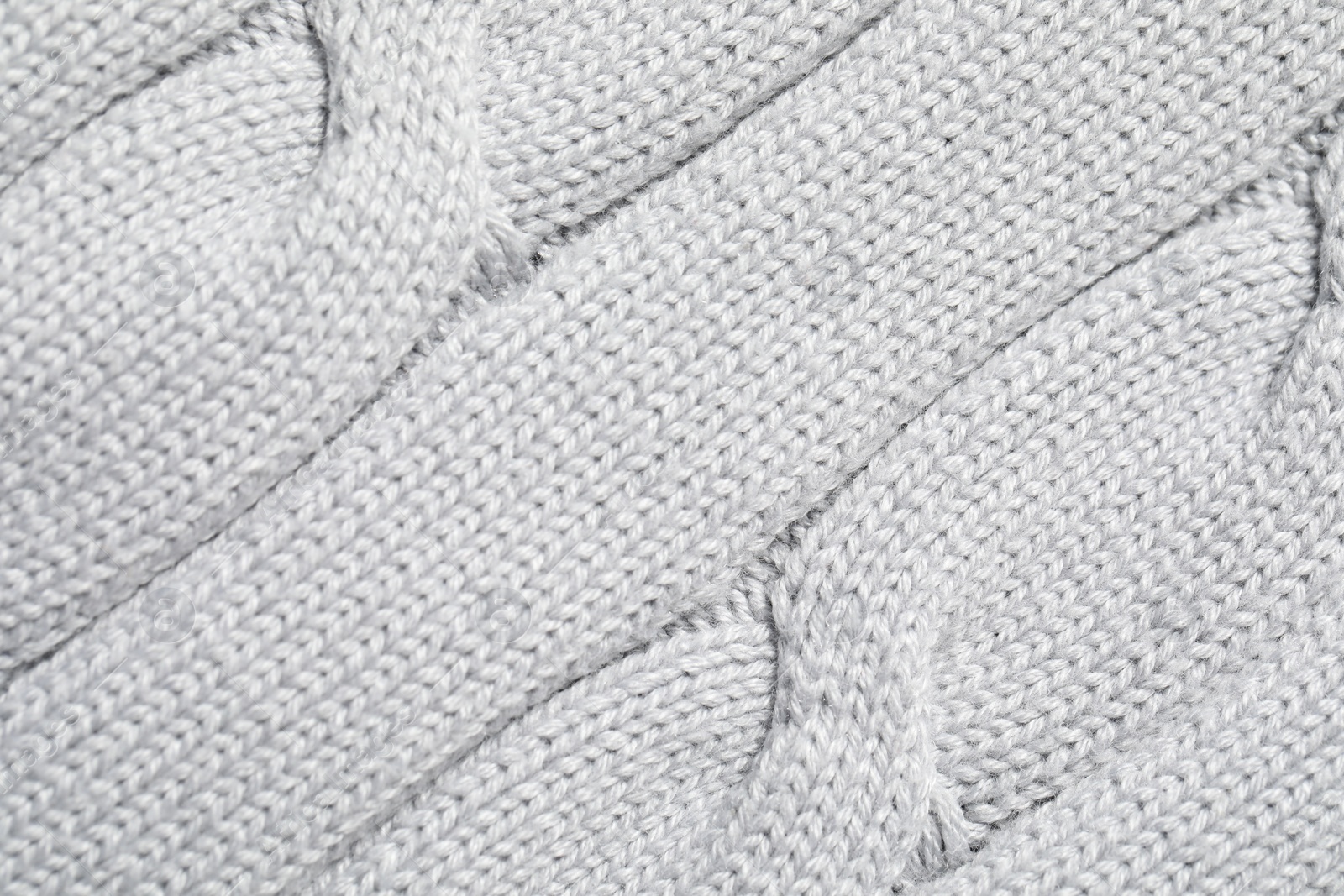 Photo of Texture of soft light knitted fabric as background, top view