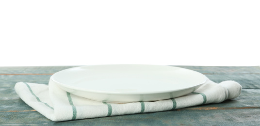 Photo of Empty plate and napkin on blue wooden table against white background