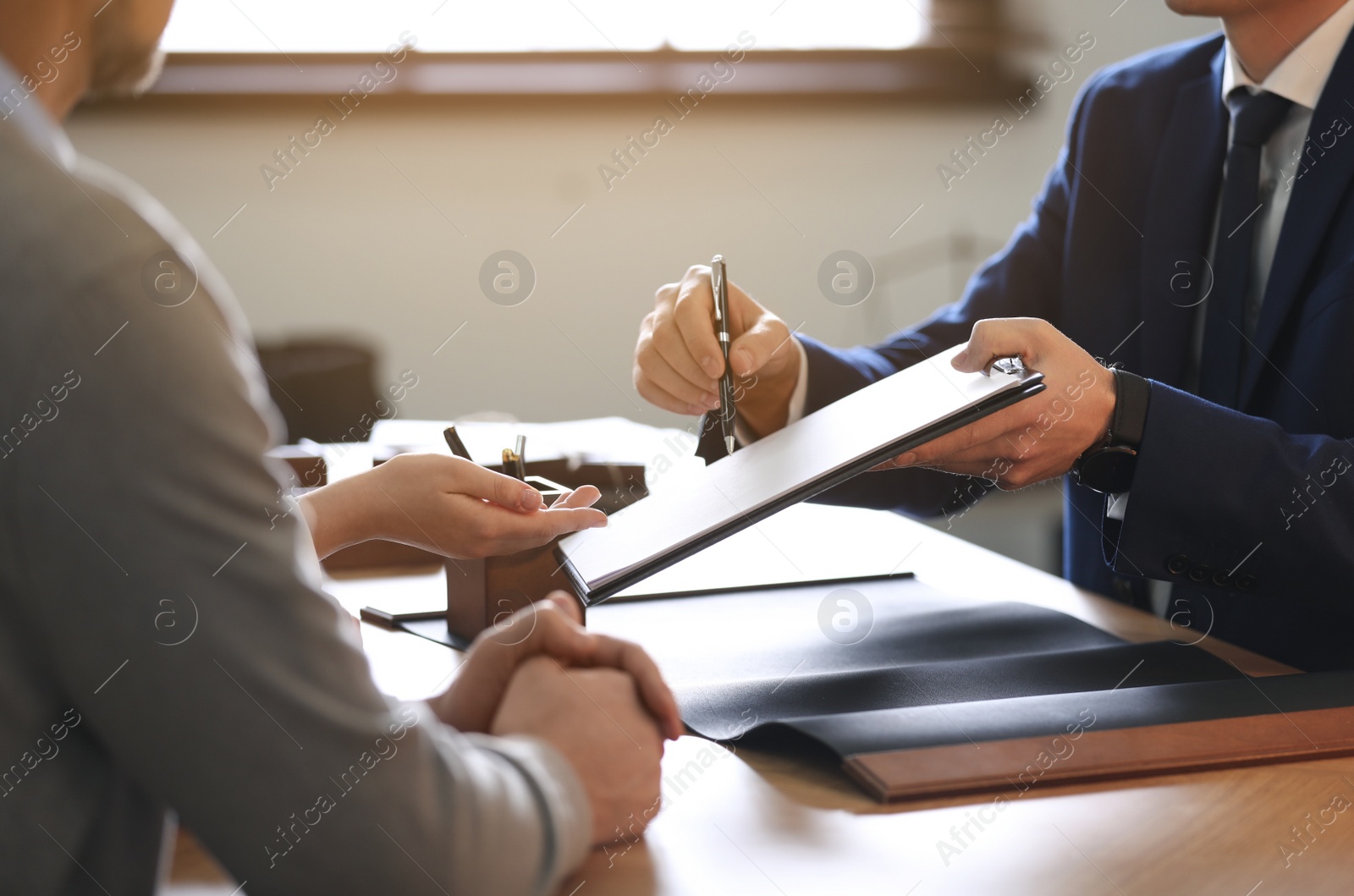 Photo of Male lawyer working with clients in office, closeup