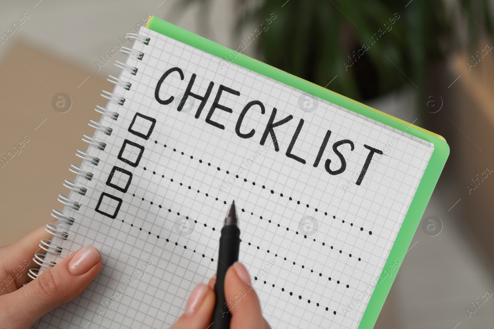 Photo of Woman filling Checklist with pen indoors, closeup