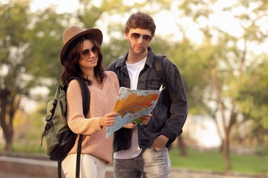 Couple of travelers with map on city street