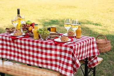 Picnic table with different tasty snacks and wine