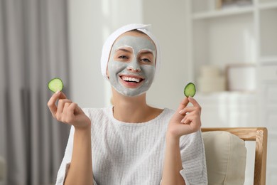 Young woman with face mask and cucumber slices at home. Spa treatments