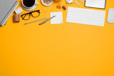 Flat lay composition with computer accessories and different office items on orange background. Space for text