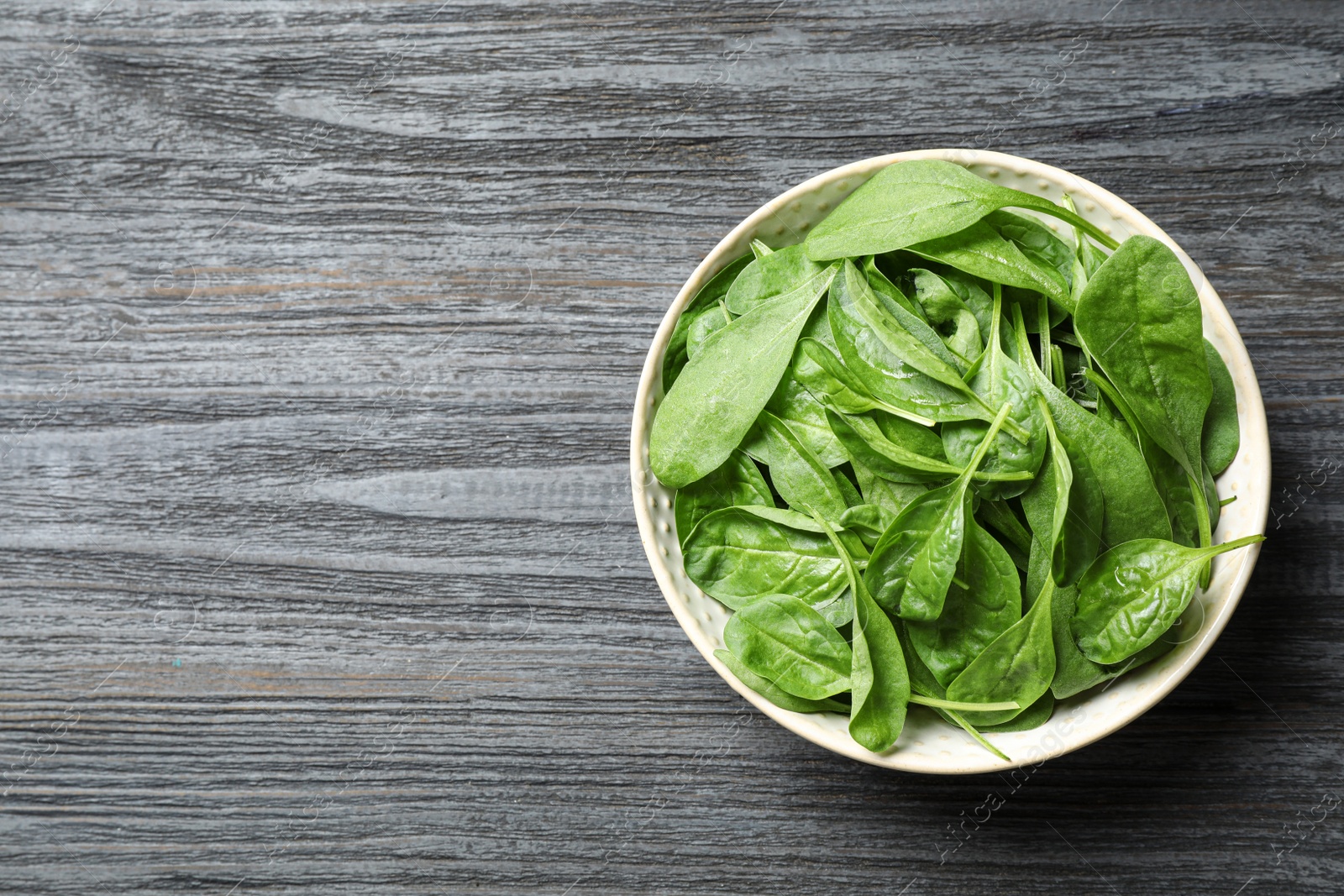 Photo of Fresh green healthy spinach on dark wooden table, top view. Space for text