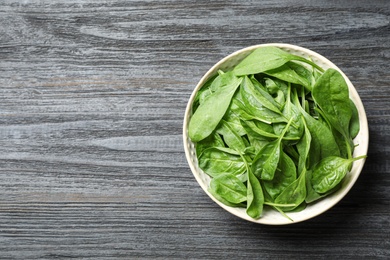 Photo of Fresh green healthy spinach on dark wooden table, top view. Space for text