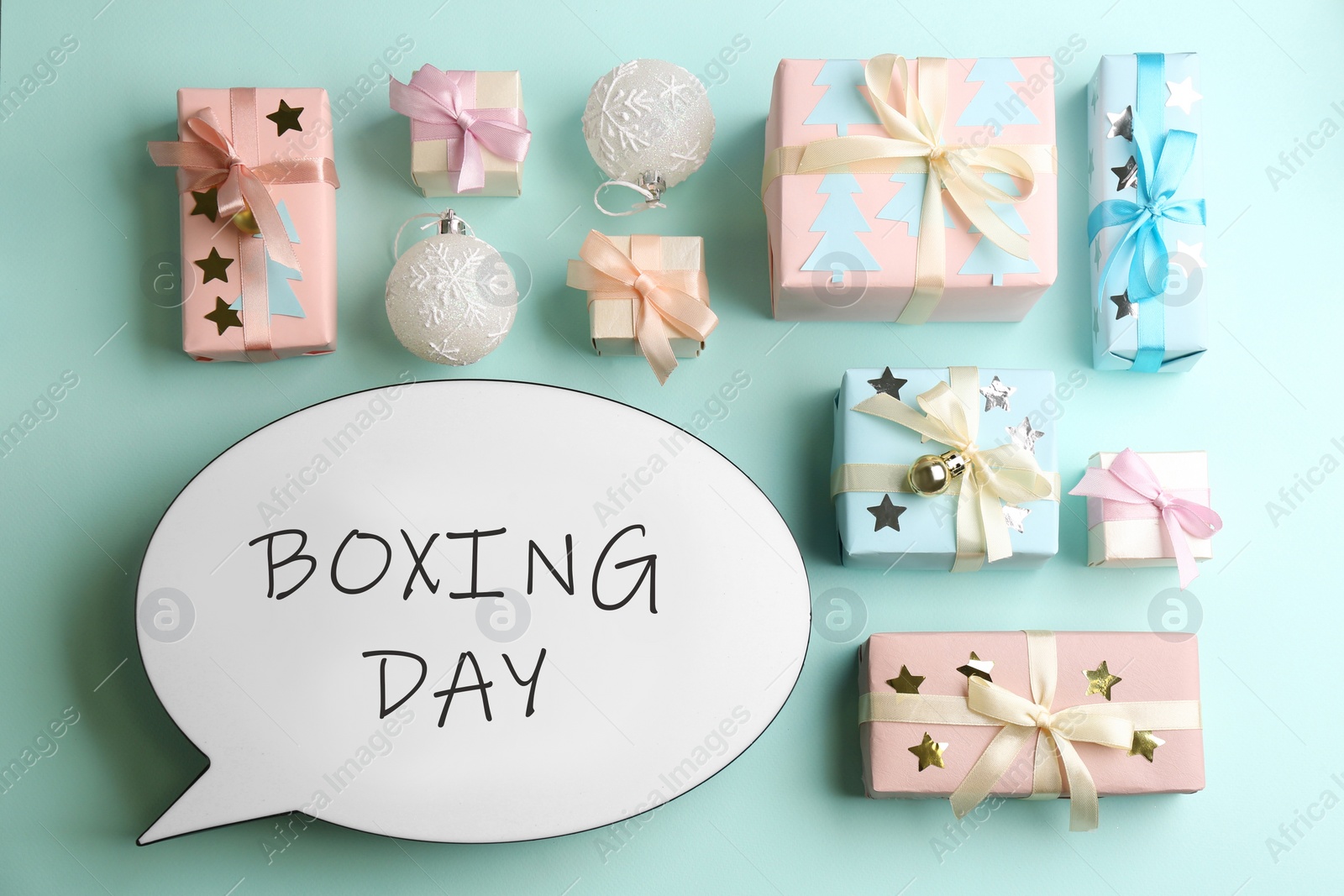 Photo of Speech bubble with phrase BOXING DAY and Christmas decorations on light blue background, flat lay