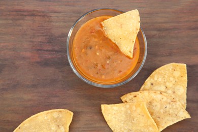 Tasty salsa sauce and Mexican nacho chips on wooden table, flat lay