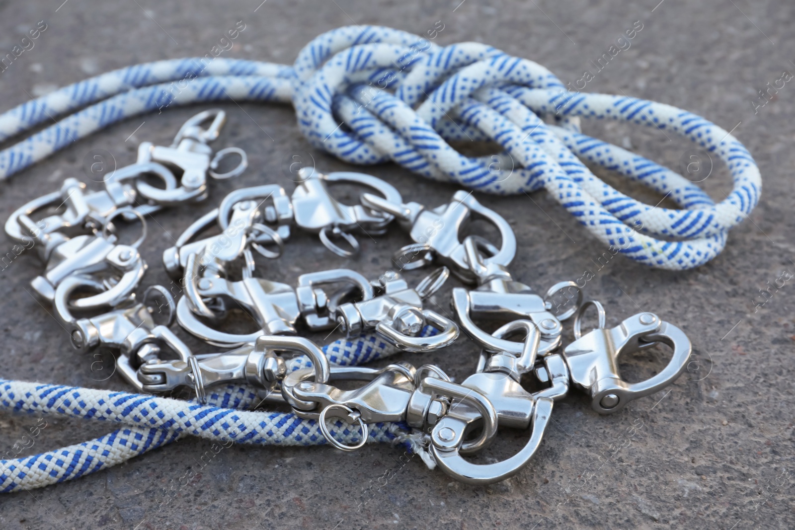 Photo of Climbing rope with carabiners on asphalt, closeup